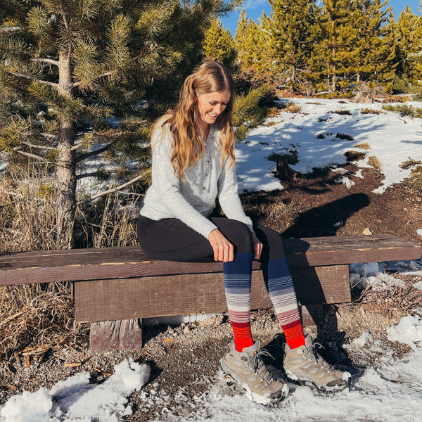 Woman sitting on a wooden bench in a snowy forest